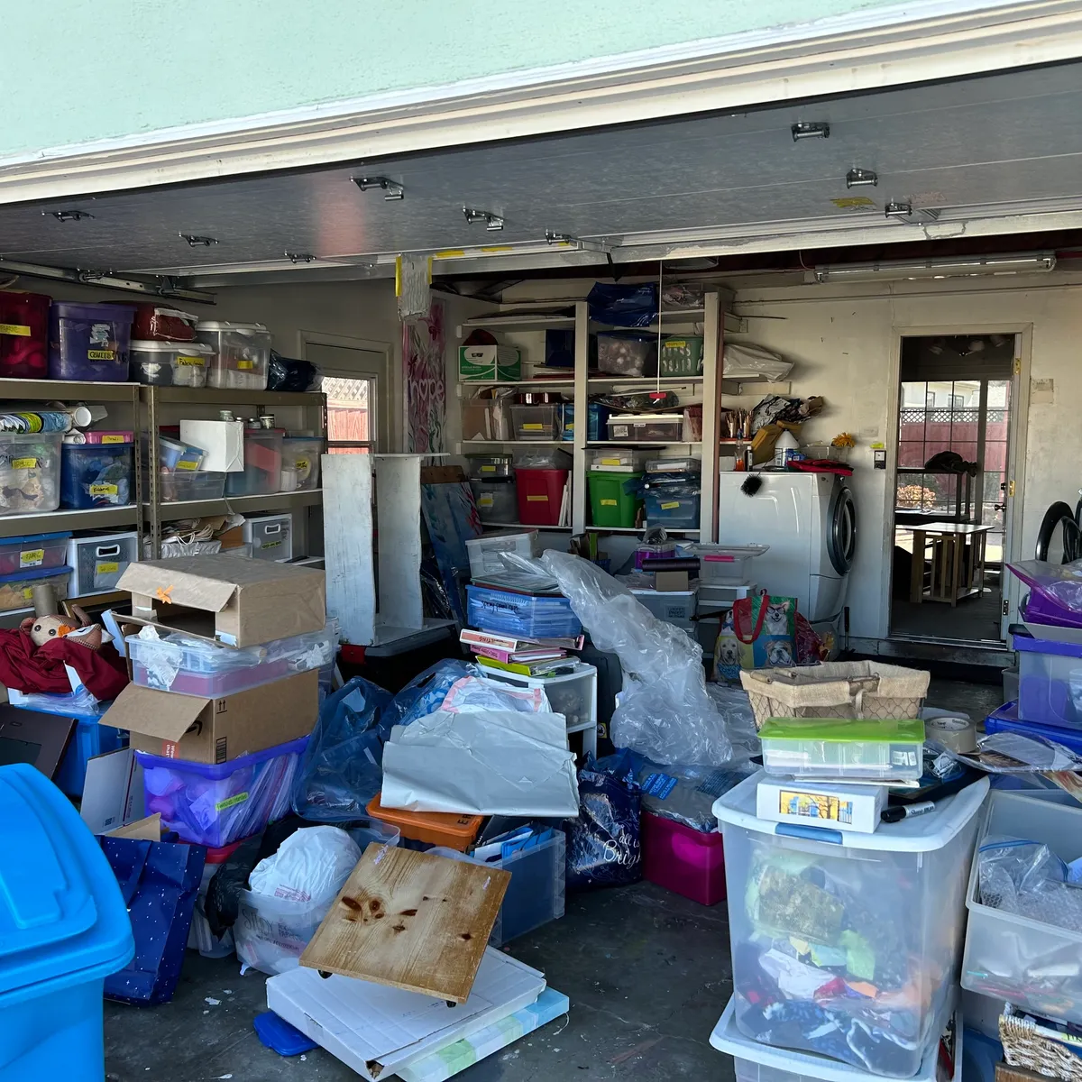 Garage packed floor-to-ceiling with totes, bins, and boxes before cleanout